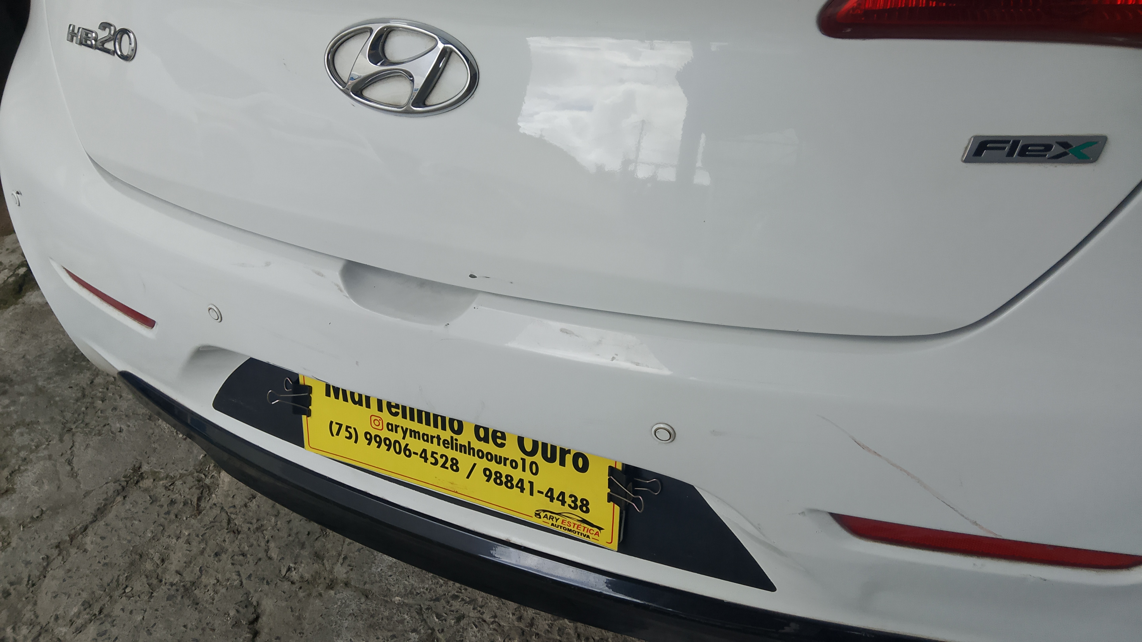Traseira de carro branco com placa da Martelinho de Ouro