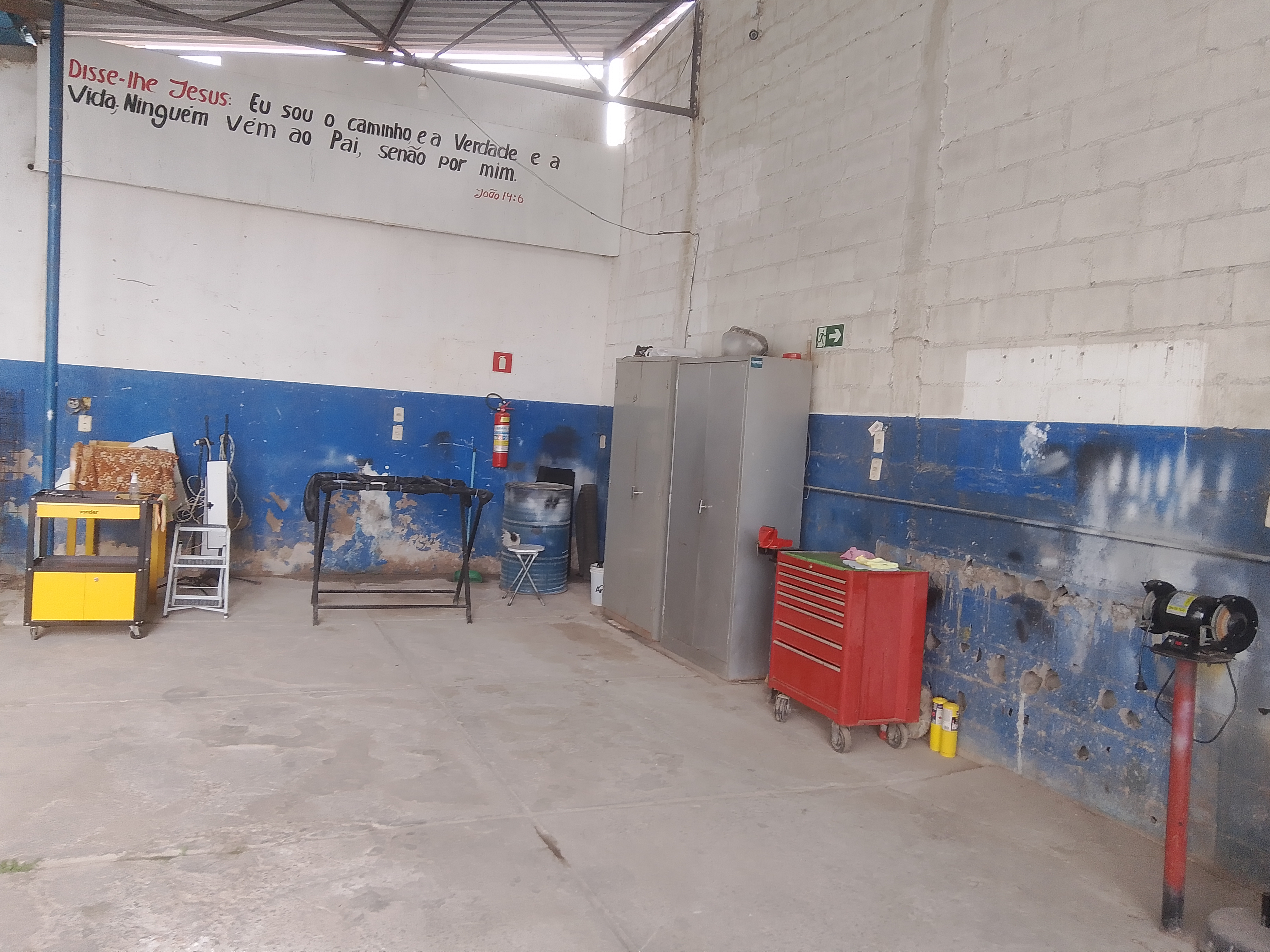 Área interna da oficina com ferramentas e elevador